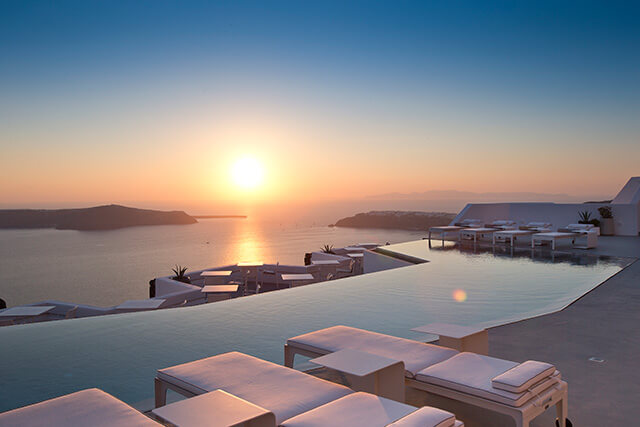 Outdoor infinity pool at luxury Grace hotel at sunset with view of the Aegean Sea