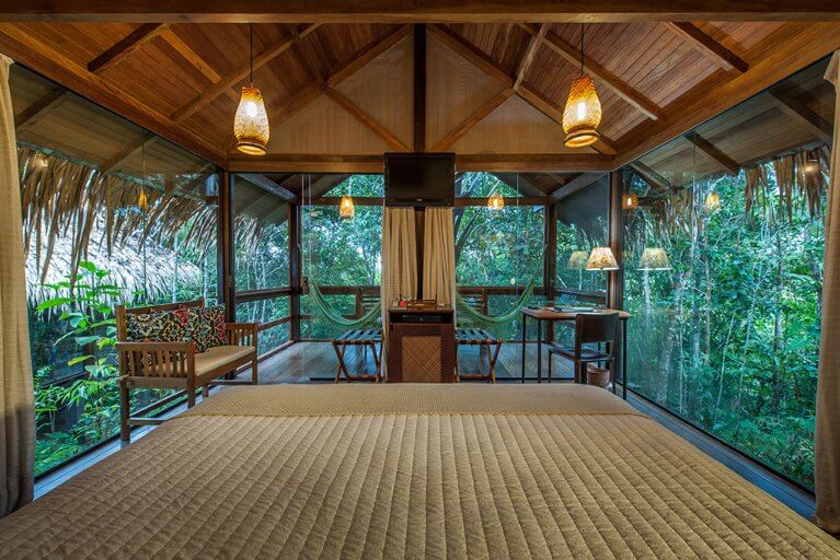 Interior of bungalow with glass walls and jungle view at Anavilhanas Lodge during luxury Amazon tour