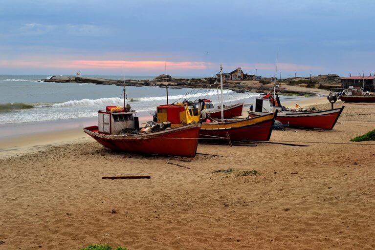 Small fishing vessels lined up on the beach in Uruguay