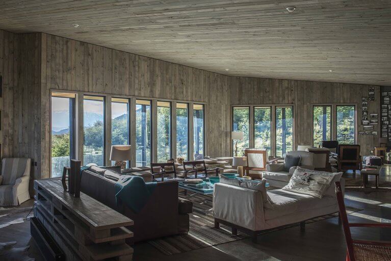 Living room of the luxury hotel Awasi Patagonia with chairs, sofas, and large windows