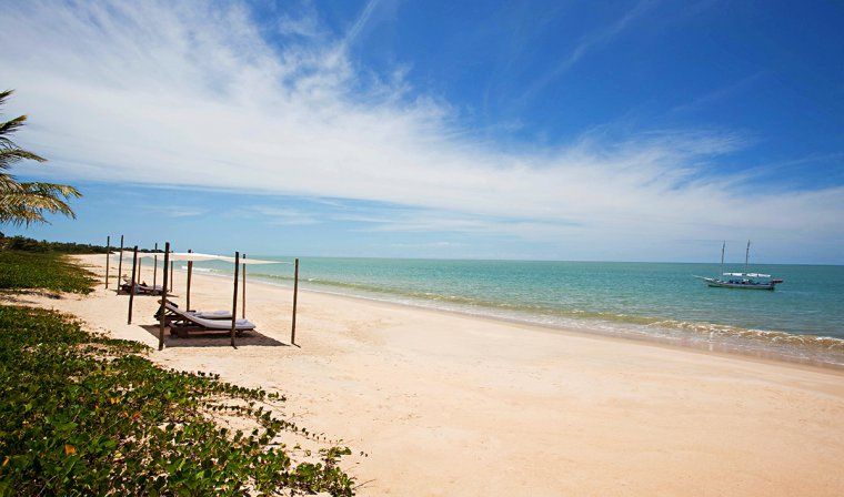 Beach with shaded lounge chairs and turquoise waters in Bahia during luxury Brazil tour