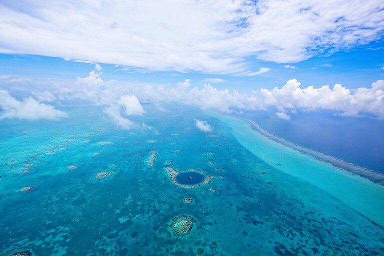 Fly over the great blue hole during a luxury tour of Belize