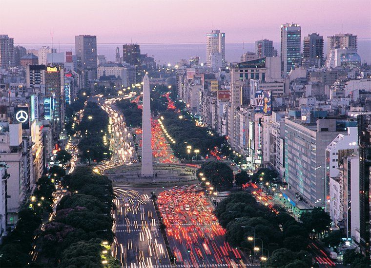 Sunset aerial view of traffic and buildings along Avenida 9 de Julio and around the Obelisk in Buenos Aires