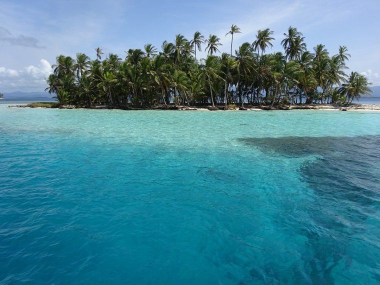 Clear turquoise waters and coconut-fringed beach of one the San Blas Islands