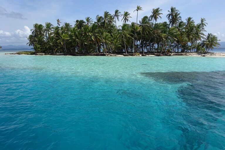 Clear turquoise waters and coconut-fringed beach of one the San Blas Islands