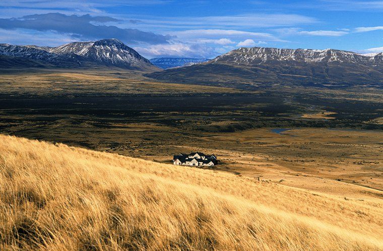 Luxury Eolo Hotel in Patagonia in the middle of grassland with no neighbors in sight and mountains in the distance