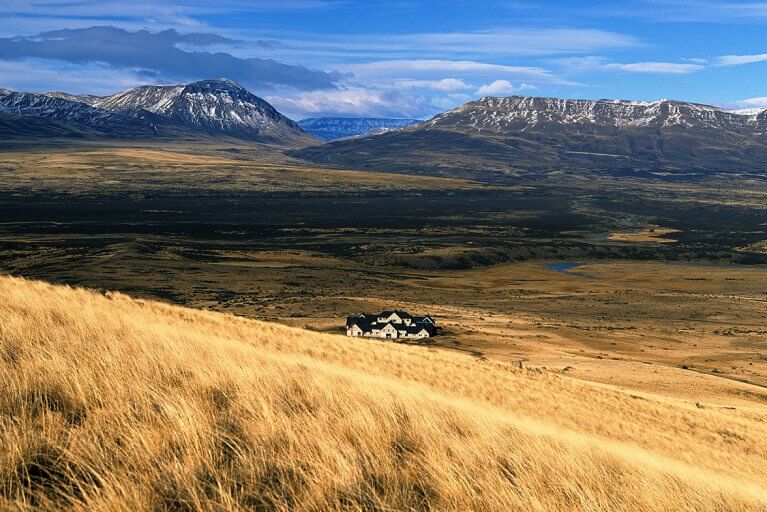Luxury Eolo Hotel in Patagonia in the middle of grassland with no neighbors in sight and mountains in the distance