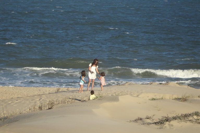 Family on Jose Ignacio beach with ocean waves in the background during a luxury Uruguay tour