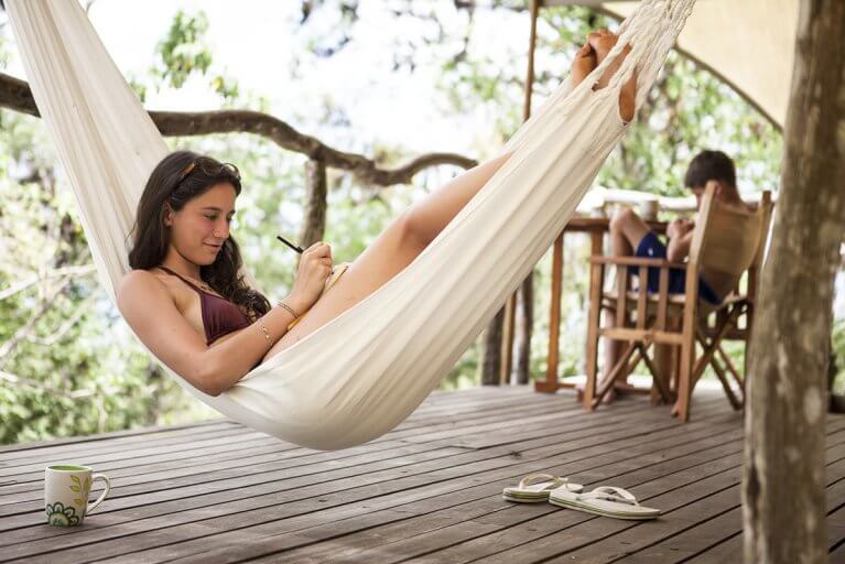 Girl lays in hammock on balcony at Safari Camp during luxury Galapagos Islands tour