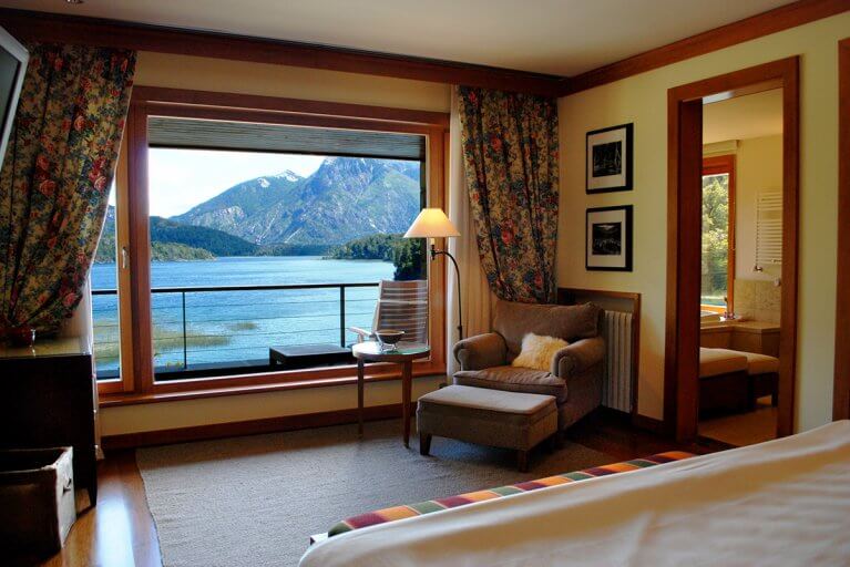 Luxury suite at the Llao Llao Hotel with a balcony featuring a beautiful lake and mountain view
