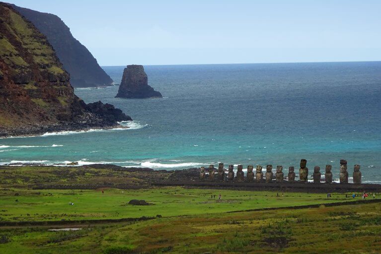 Line of Moai statues from a distance against backdrop of the sea on Easter Island during a luxury trip in Chile