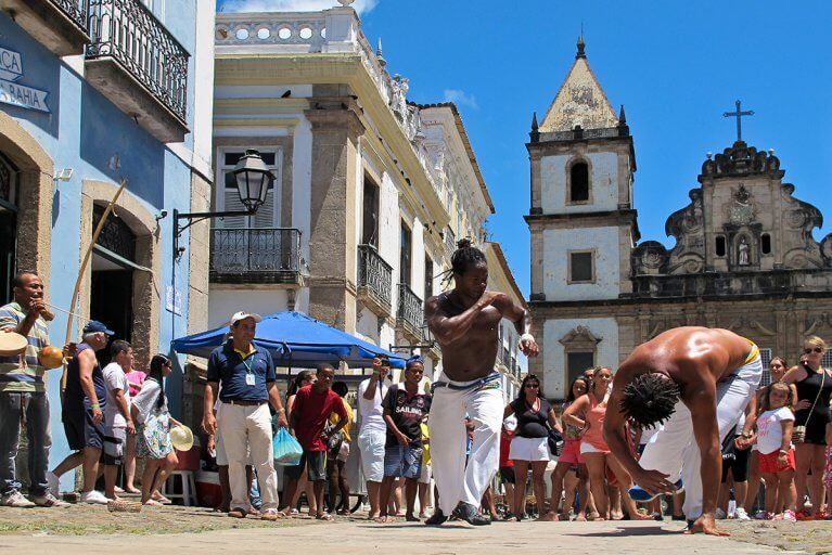 Two men performing capoeira to a crowd on the streets of Pelourinho in Salvador during a luxury tour of Brazil