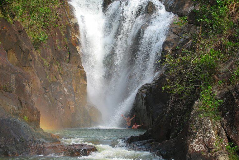 Trekking excursion to a secluded waterfall to swim under the cascade, during a private Belize tour