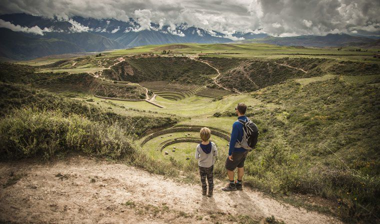 Father and son looking out towards the circular terraced depressions of the Moray ruins during a private hiking excursion