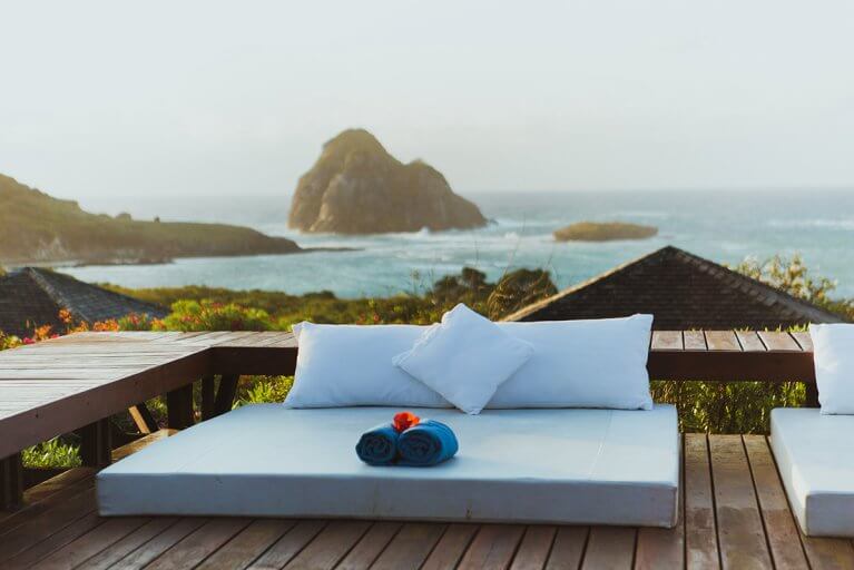 Terrace with lounge cushions and ocean view at Pousada Maravilha property