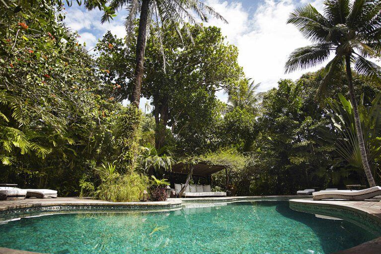 Outdoor pool and sun loungers surrounded by trees at Casa Uxua Hotel during luxury Brazil trip