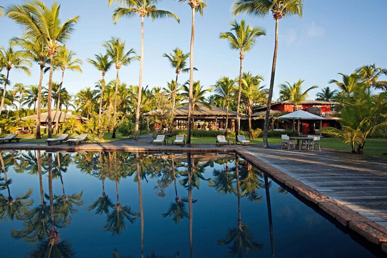 Outdoor pool and palm trees at Fazenda São Francisco Corumbau Hotel in Bahia, Brazil