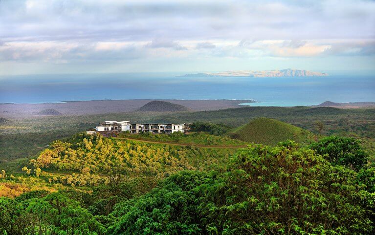 Luxury Pikaia Lodge from afar surrounded by nature with ocean in background in Galapagos Islands