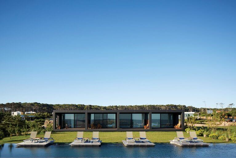 Outdoor pool and sun loungers in front of Bahia Vik on a sunny day during a luxury Uruguay tour