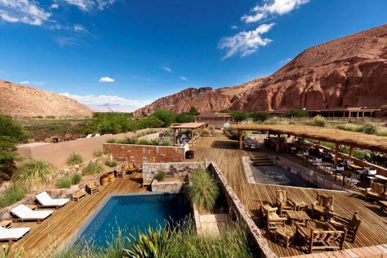 Pool and large wooden deck area at Nayara Alto Atacama near red mountains during luxury tour of Chile