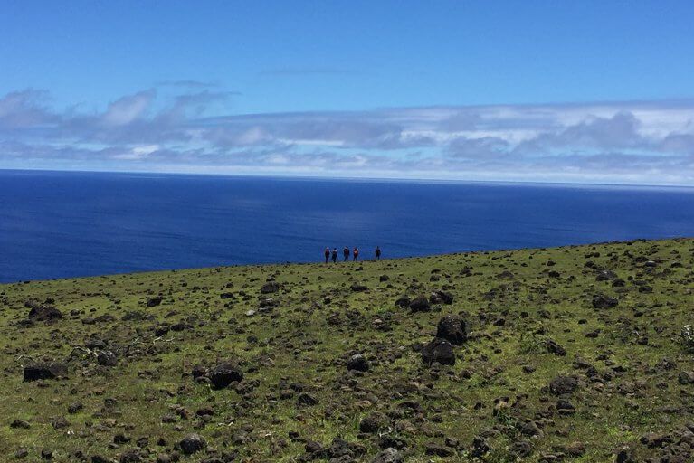 Small group of people looking out to the Pacific Ocean during a private hiking tour on Easter Island