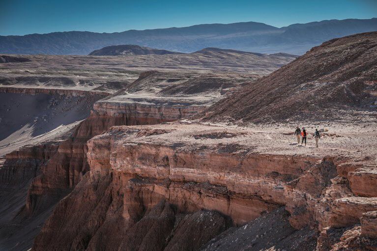 A small group of people enjoy a private hike along a mountain ridge in the Atacama Desert in Chile