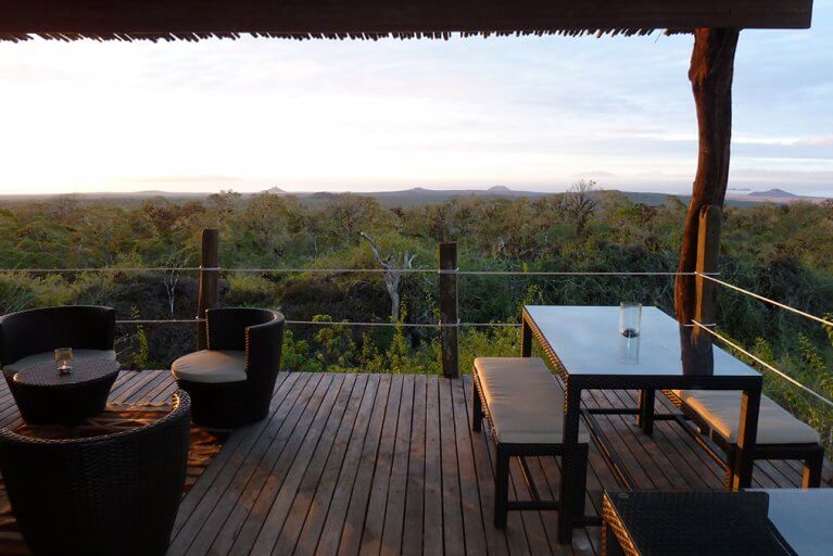 Dining area on balcony with view of island at Safari Camp during luxury Galapagos tour