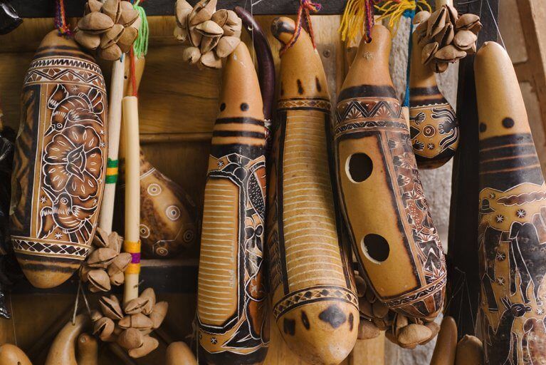 Traditional Peruvian musical instruments made from gourds with carved designs hanging from strings