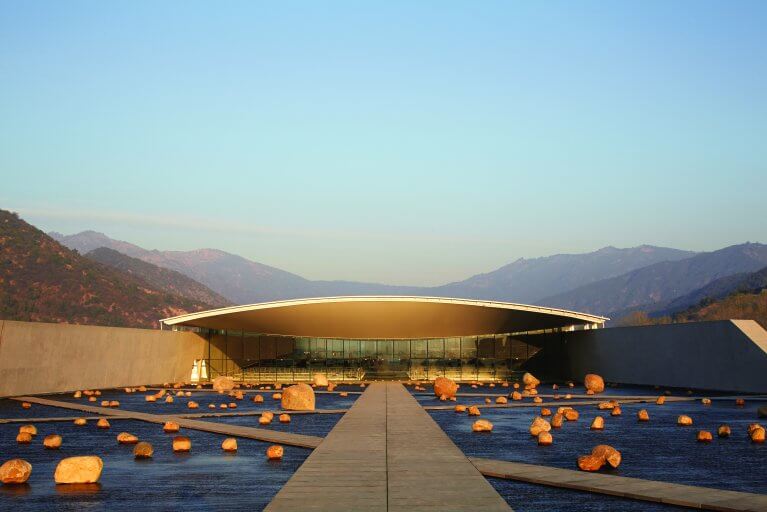 Sleek, modern, entrance of Viña Vik winery in Chile with the Andes mountains in the distance