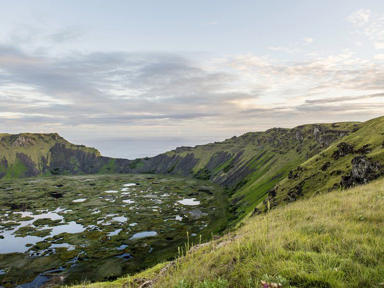 Rano Kau crater lake with grass growing on the rocky walls during a private Easter Island tour