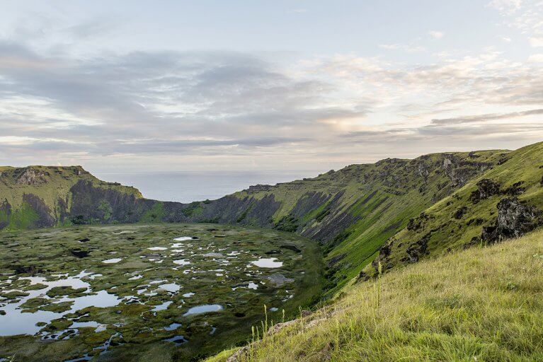 Rano Kau crater lake with grass growing on the rocky walls during a private Easter Island tour