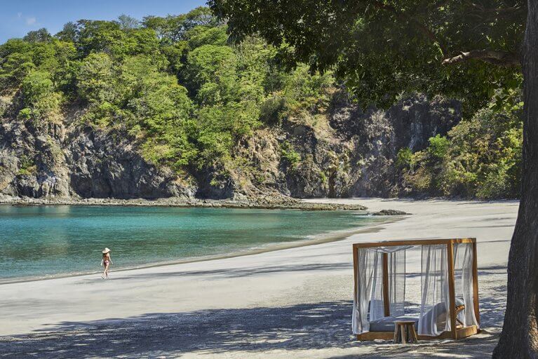 Woman walking along the beach at the Four Seasons Costa Rica, a luxurious resort in the Papagayo Peninsula