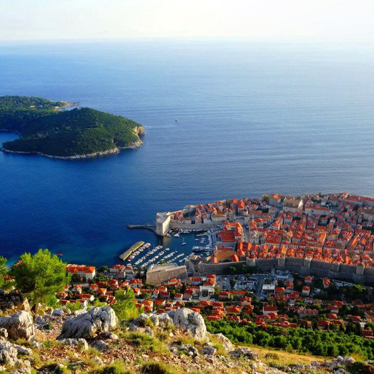 View from hillside above Dubrovnik's Old Town with fortified walls and sea