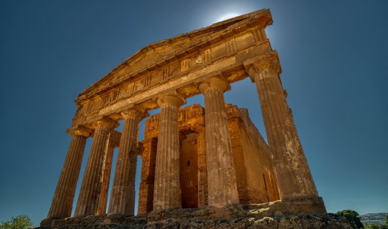 Looking up at columns of a ruined Roman temple in Valley of the Temples on a sunny day in Agrigento, Italy