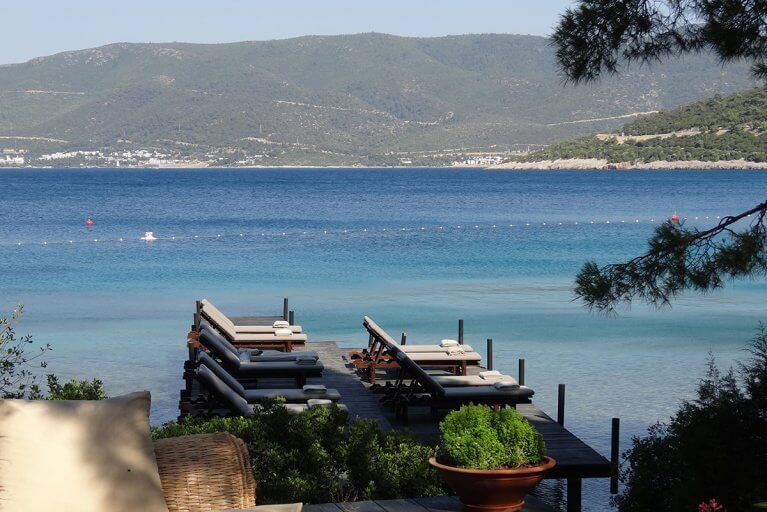 Deck with sun loungers by the sea at Amanruya Beach Club