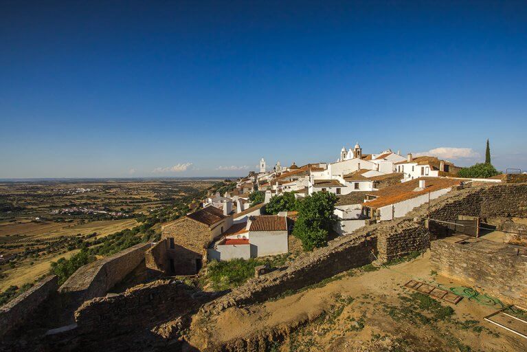 White buildings in Monsaraz village on a hillside in Alentejo, Portugal