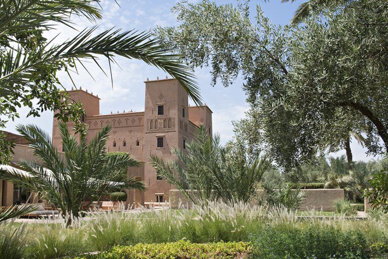 Exterior view of the main kasbah and gardens of Dar Ahlam luxury hotel in the Skoura Oasis