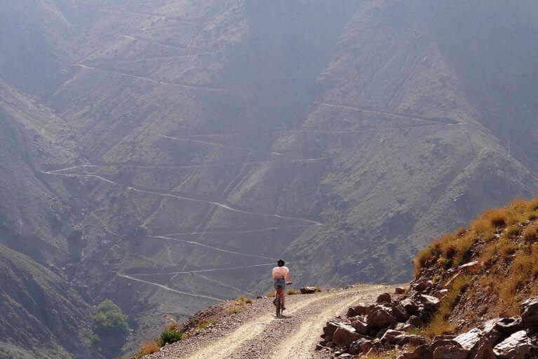 Woman on a winding mountain road during a mountain biking excursion