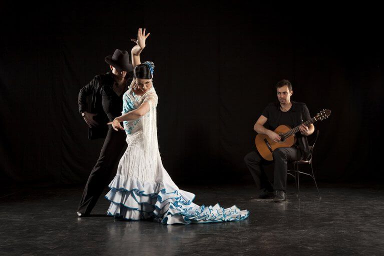 Two flamenco dancers accompanied by a guitar player performing at a flamenco show in Andalusia, Spain
