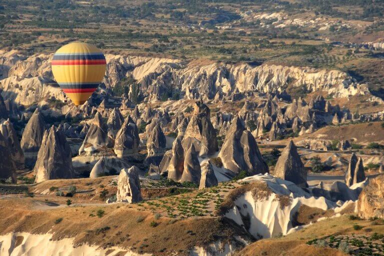 Hot air balloon floats over fairy towers in Cappadocia