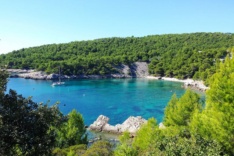 Sailboat anchored in turquoise bay off of Hvar island in Croatia