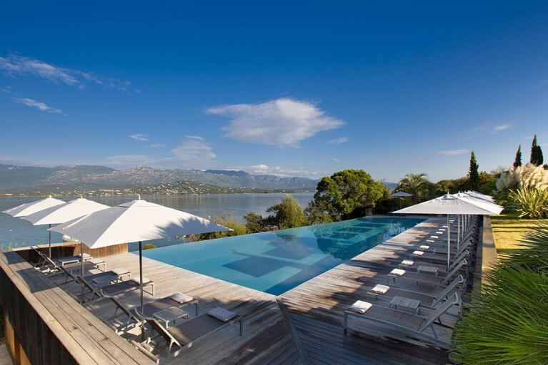 Outdoor infinity pool overlooking sea and mountains at Casadelmar luxury hotel in Porto Vecchio
