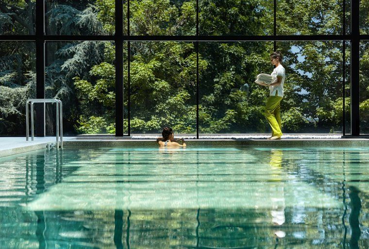 Worker brings a towel to guest in pool at the spa of Six Senses hotel