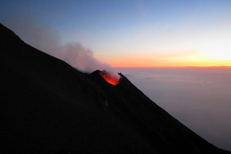 Glowing lava from Stromboli volcano erupting in the evening