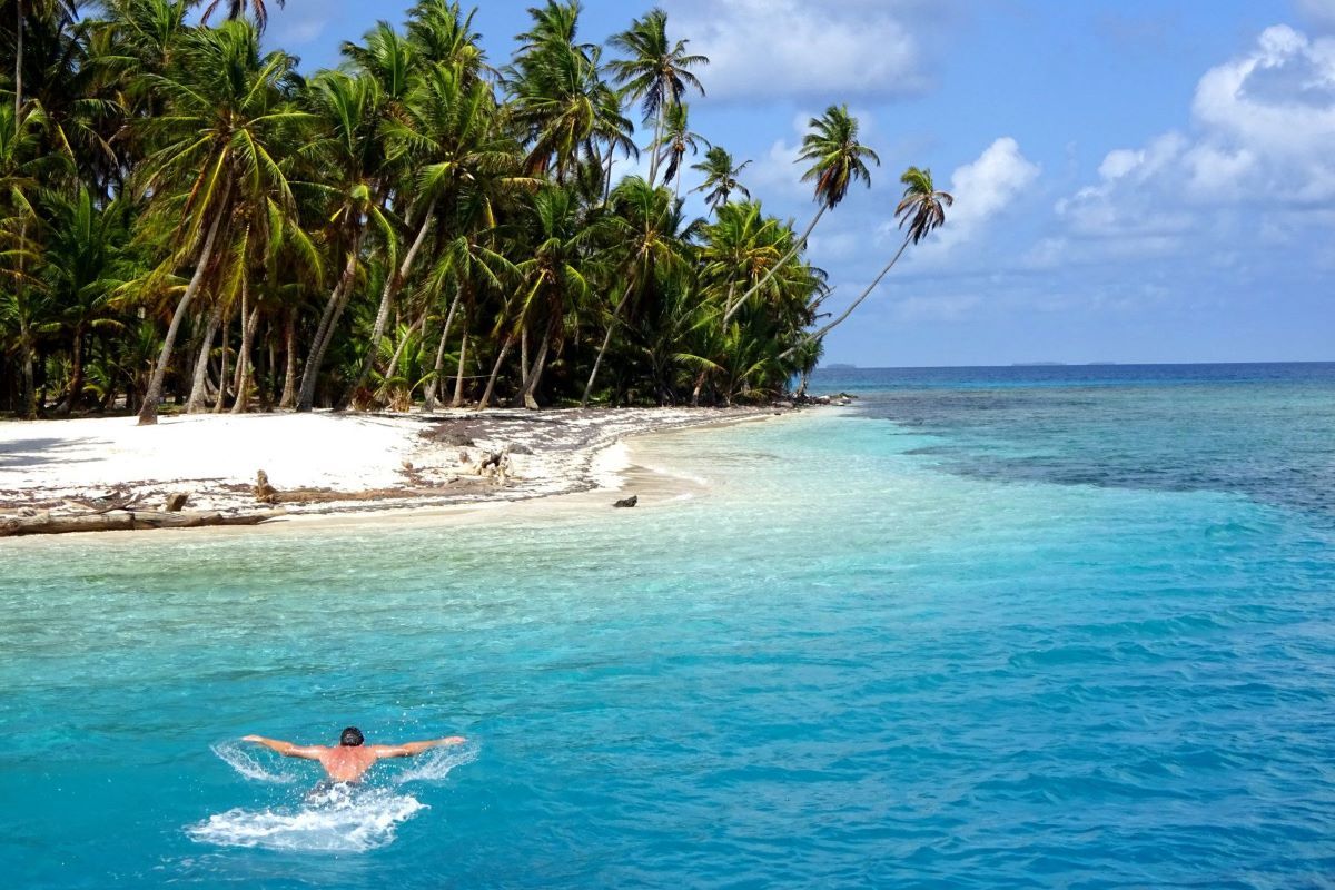 Man swimming around an unihabited island in the San Blas Islands in Panama