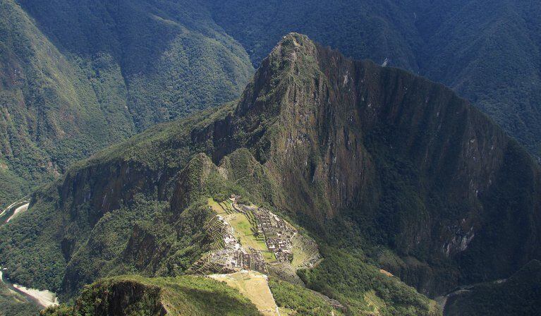 Aerial view of ancient Incan ruins called Machu Picchu surrounded by green Andes mountains including Huayna Picchu