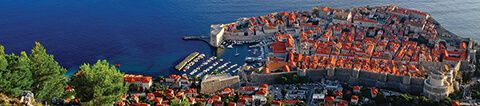 View from hillside above Dubrovnik's Old Town with fortified walls and sea