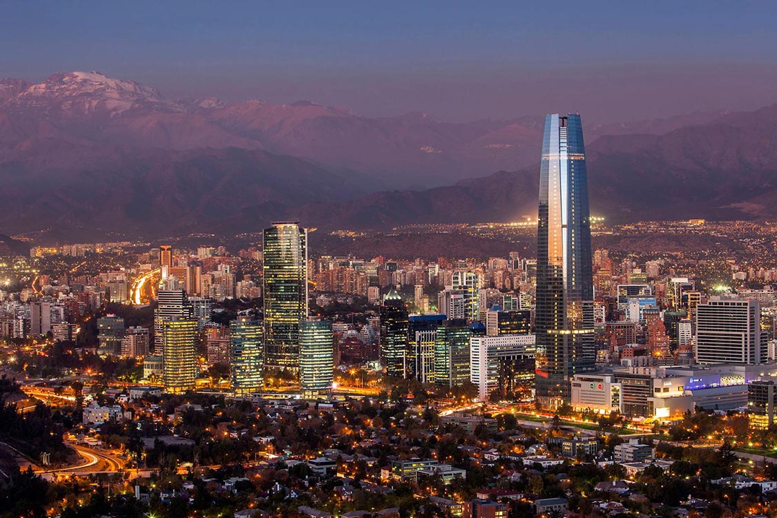 Cityscape of Santiago with Andes mountains in background at dusk