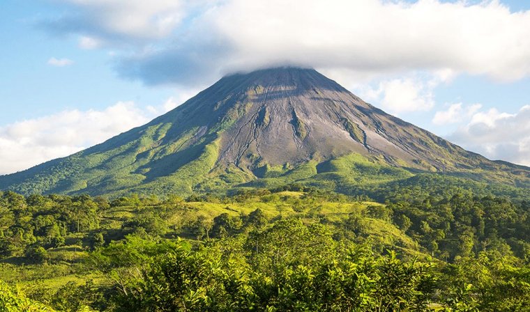 Lanscape showing the slopes of Costa Rica's Arenal Volcano, with the crater shrouded in clouds