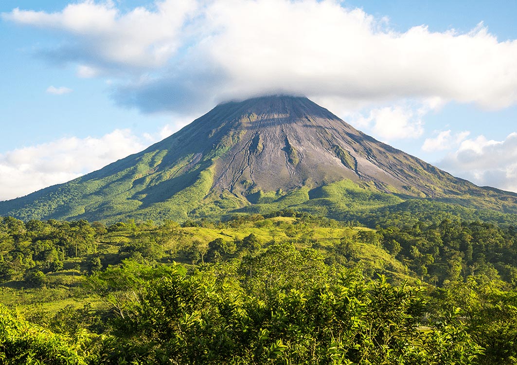 Lanscape showing the slopes of Costa Rica's Arenal Volcano, with the crater shrouded in clouds